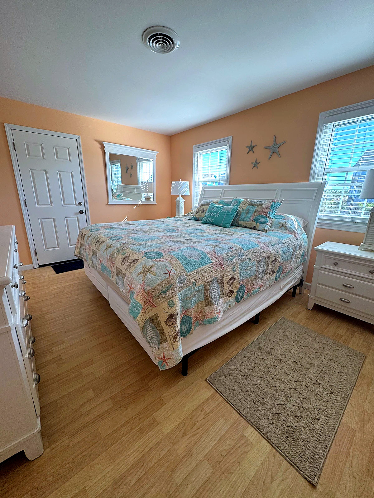 King bedroom with peach walls and a seashell quilt